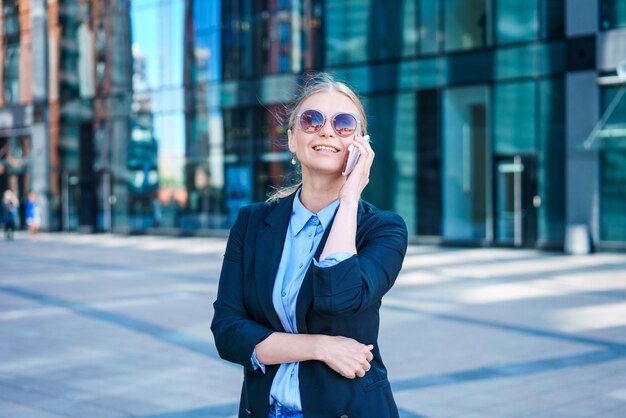 Photo business woman with phone near office portrait beautiful smiling girl