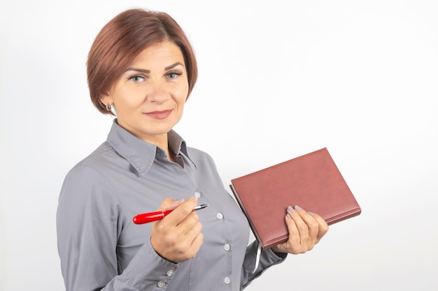 Photo business woman with a red pen and notebook in hands