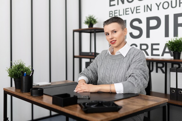 Business woman with a short haircut caucasian appearance with a smile looking at the camera while