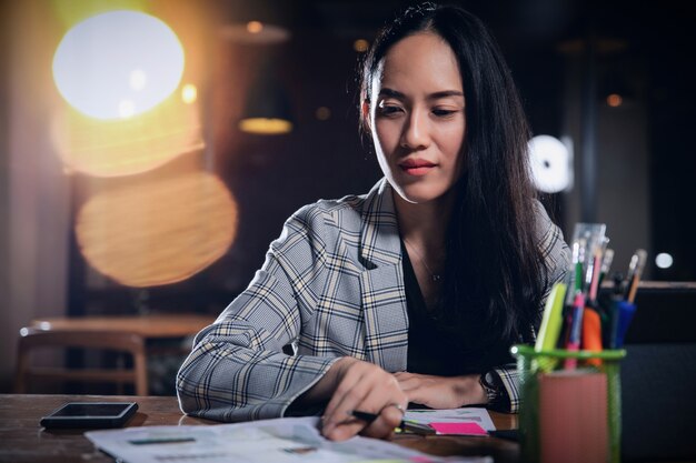 Business woman working alone in office at night