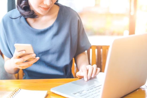 Business woman working in computer and phone at work