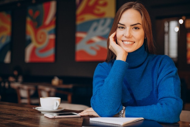 Donna d'affari che lavora al computer portatile in un bar