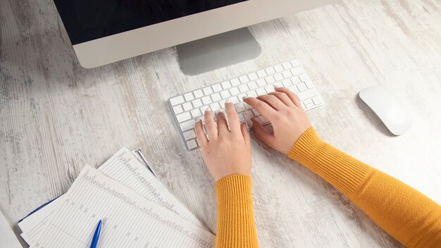 Business woman working in office with computer holding documents