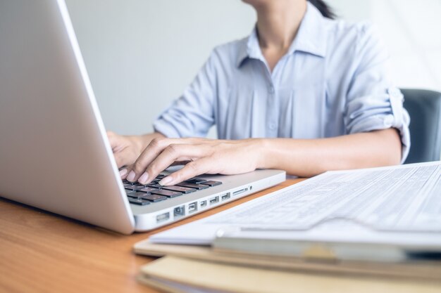 Business woman working at office with laptop and documents on his desk. business concept.