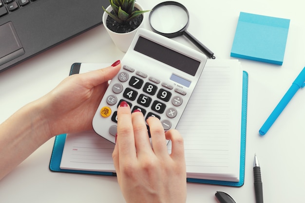 Business woman working with financial data hand using calculator