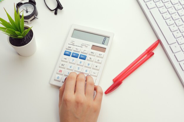 Business woman working with financial data hand using calculator