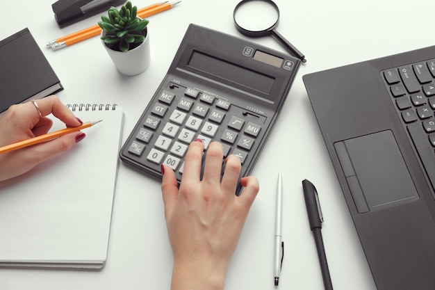 Business woman working with financial data hand using calculator