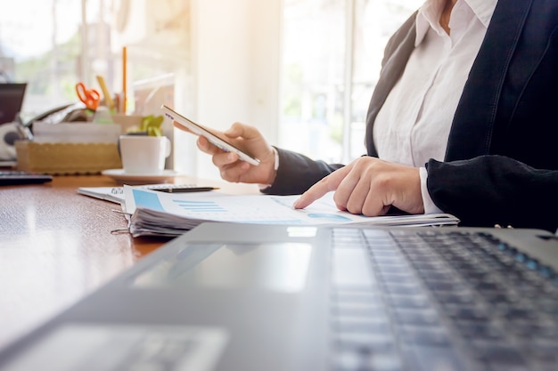 Business woman at working with financial reports and laptop computer in the office