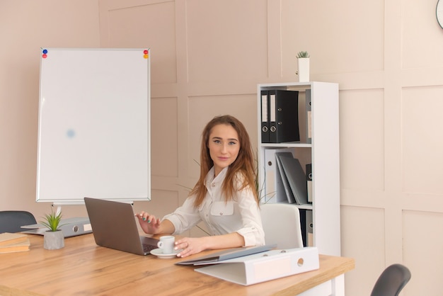 Business woman works in a laptop. portrait of a woman in the office.