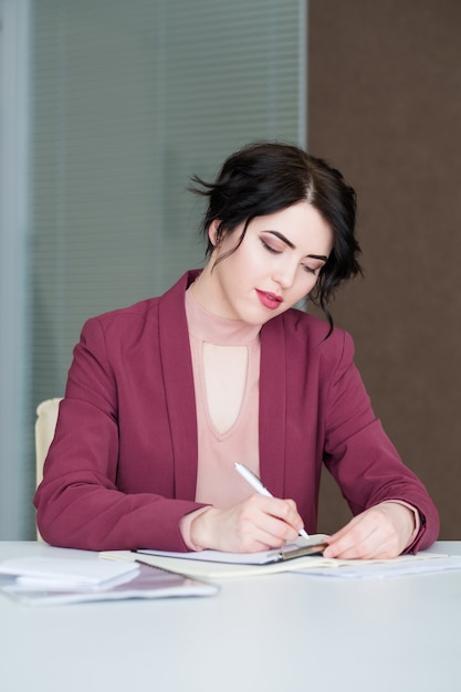 Business woman writing on a clipboard