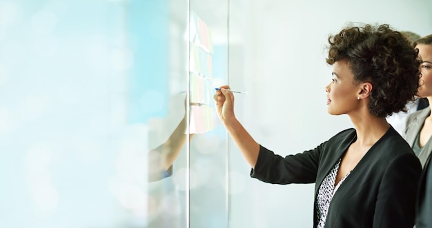 Foto donna d'affari che scrive e pianificazione del team per la strategia di pianificazione o il brainstorming di note adesive sul mockup femmina in scrittura post-it o collaborazione di lavoro di squadra per piani o attività di idee di crescita aziendale