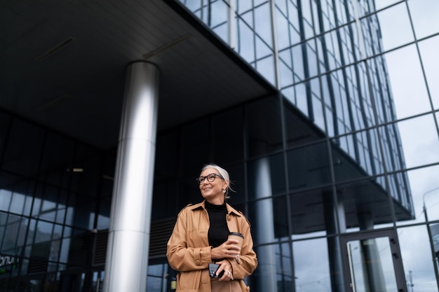 Business woman  years old against the backdrop of a huge office skyscraper