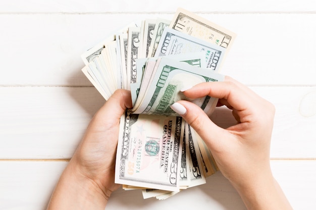 Business womans hands counting one hundred and various dollar bills