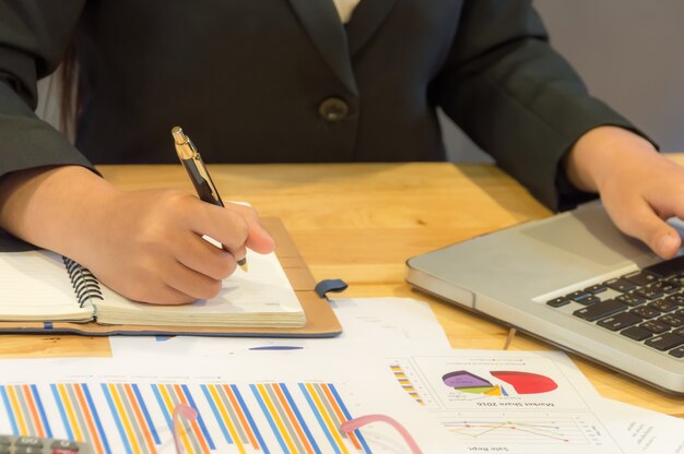 Business women are planner, using data from Graph paper and notebook