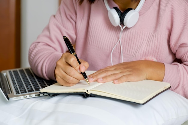 Фото Бухгалтер бизнес-леди рука ручку и использовать ноутбук, делая счет для уплаты налогов на кровати, работа из дома концепции.