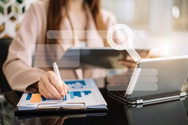 Business women hand working with tablet and laptop computer with documents on office desk in office