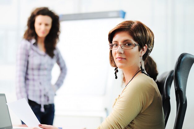 Business women holding a conference writing on an a board in an office