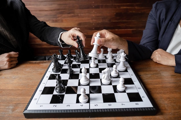 Business women play chess on board challenges planning business strategy to success concept