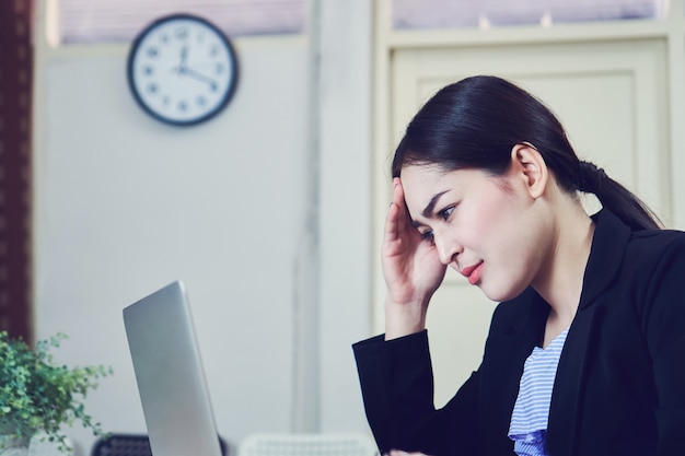 Business women sit and strain computer screen for long time. Because the work has been ove