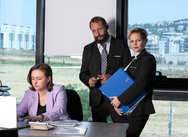 Business women in trendy suit reading information from documents before meeting with partners. Financial director ready affirm official paper with signature. Business people talking before meeting