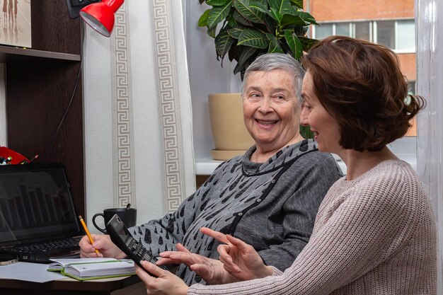 Business women working Portrait of two women with calculator smiling