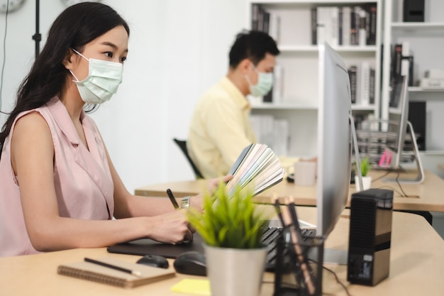 Foto lavoro aziendale in ufficio con maschera facciale in quarantena di allontanamento sociale durante affetto covid19