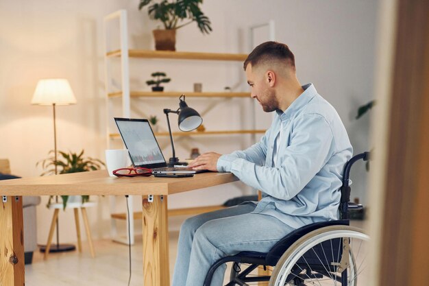 Photo business worker disabled man in wheelchair is at home