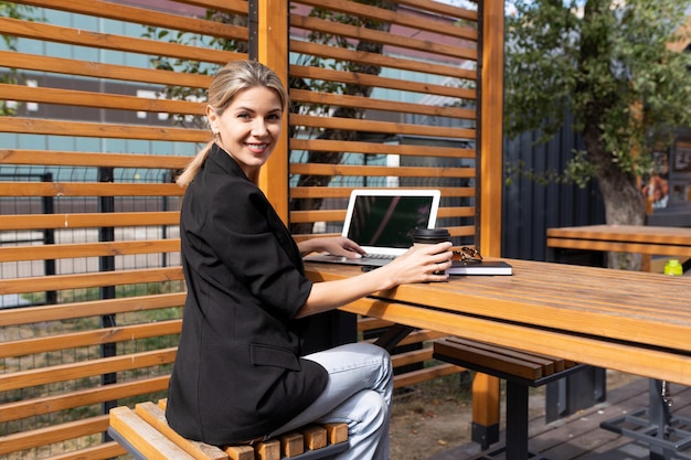 Business young woman with a laptop at a table in a cafe