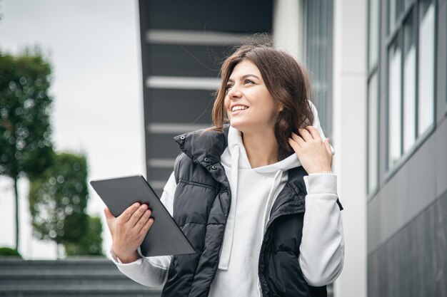 建物の背景にタブレットを持つビジネスの若い女性