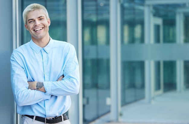 Photo businesses across the globe will know my name. shot of a handsome young businessman standing alone in the city with his arms crossed.