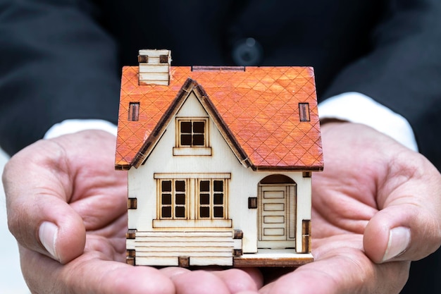 Businesses on buying selling homes businessmen with models house put on hand wearing black suit white shirt