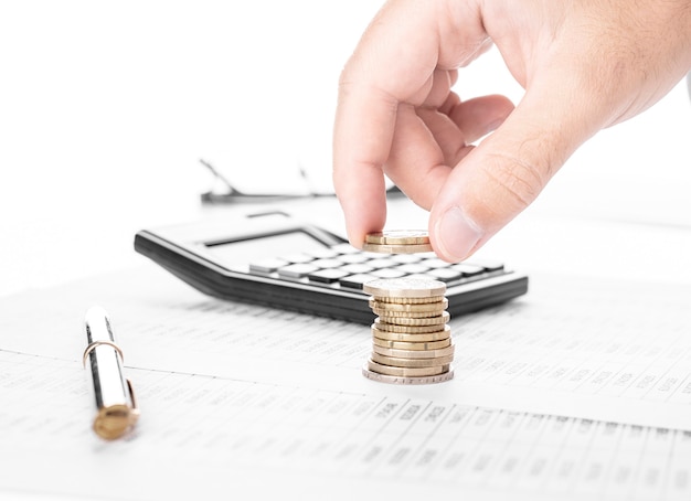 Businessman or accountant counting money and making stack of coins on financial data. Financing, Accounting and Banking Concept.