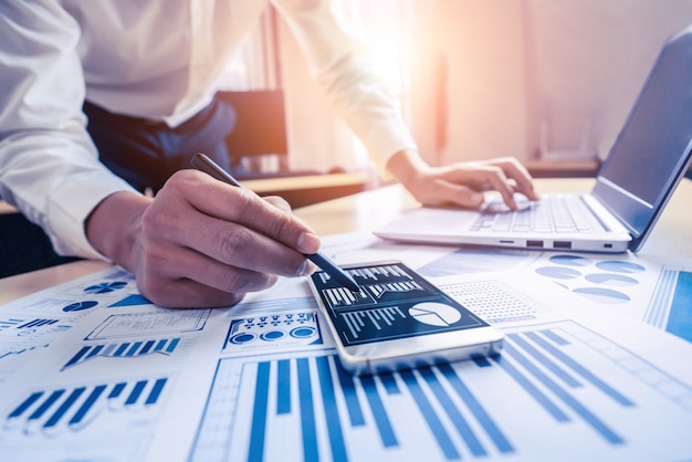 Businessman accountant or financial expert analyze business report graph and finance chart at corporate office. Concept of finance economy, banking business and stock market research.