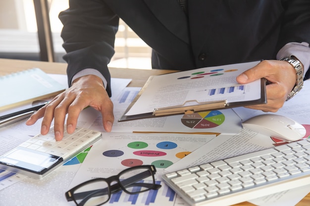 Businessman or accountant working on calculator to calculate business data concept.