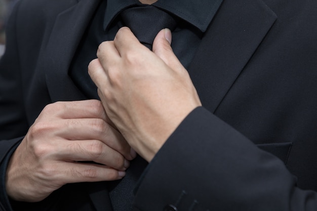 businessman adjusting the neck tie