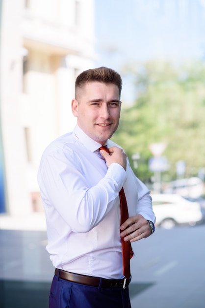 Businessman adjusts his tie