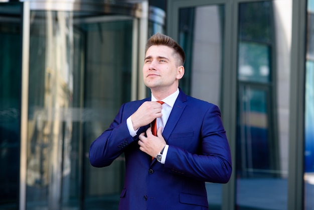 Businessman adjusts his tie.