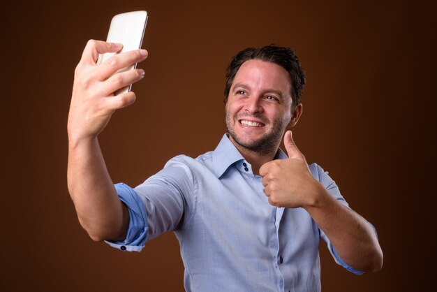 Businessman against brown wall