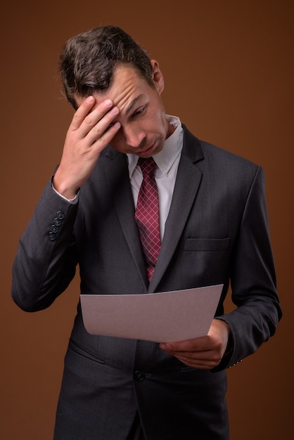  businessman against brown wall