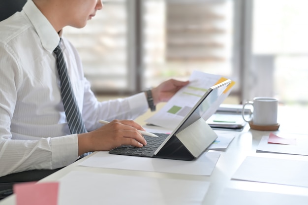 Businessman analyzing financial statistics displayed on the tablet screen.