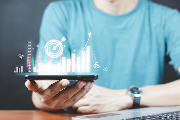タブレットビジネスファイナンステクノロジーからの外国為替取引グラフの財務データを分析するビジネスマン
