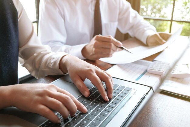 Businessman analyzing investment charts and pressing calculator buttons over documents Accounting Concept