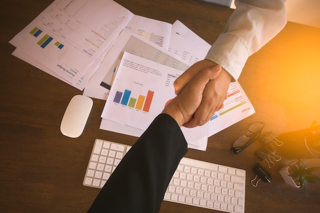 Businessman analyzing investment charts with laptop computer on office desk table.