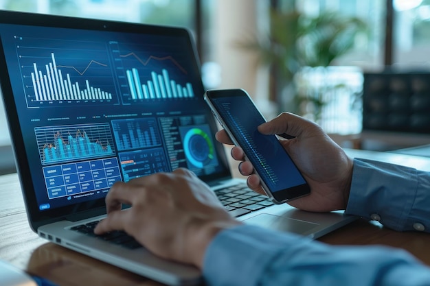 businessman analyzing investment charts with laptop and mobile phone investment and trading concept