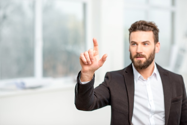 Businessman or architect touching virtual screen standing in the room