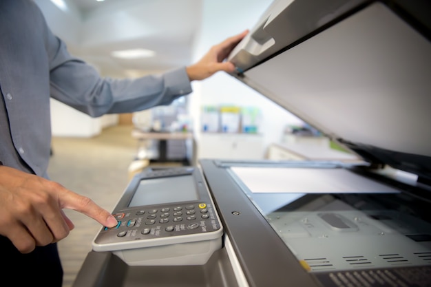 Businessman are press button on panel of printer, photocopier.