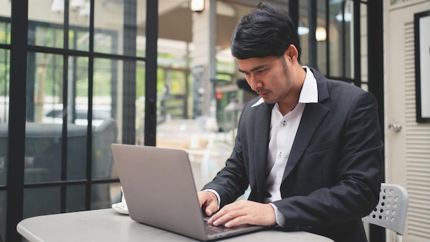 L'uomo d'affari sta digitando sulla tastiera del laptop per lavorare