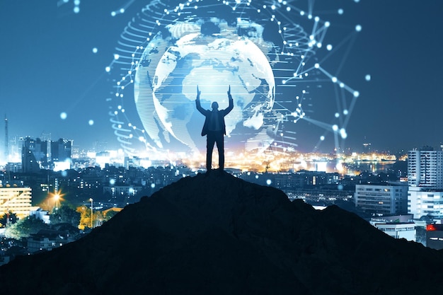 businessman on backlit hill holding abstract polygon globe hologram on illuminated night city background polygonal network science communication programming and earth concept