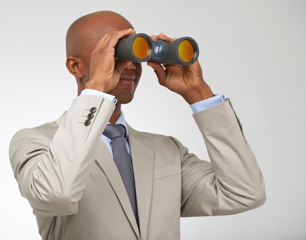 businessman binoculars and job or search opportunity for employment professional or white background male person looking and future goals or growth at company in studio career or mockup space