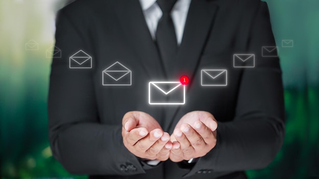 Photo businessman in black suit holding email icon